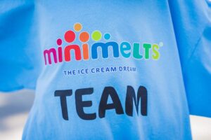 Mini Melts-ის ლოგო და წარწერა "THE ICE CREAM DREAM TEAM" ცისფერ მაისურზე.